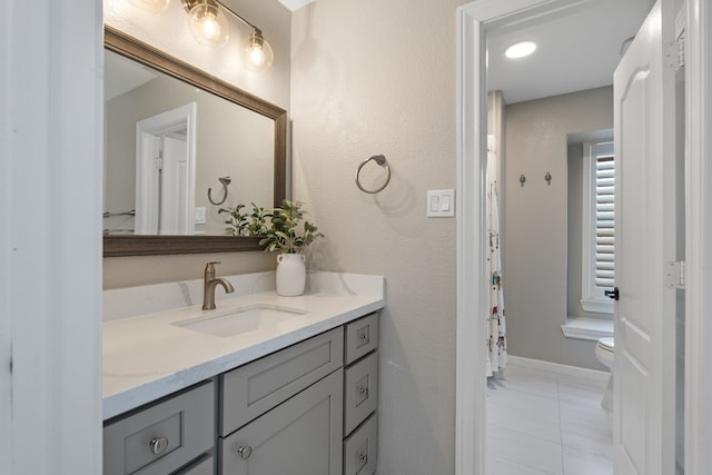 full bathroom with tile patterned flooring, toilet, vanity, and baseboards