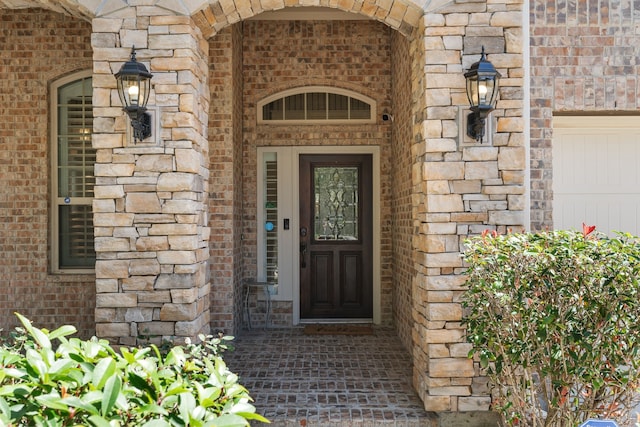 entrance to property featuring stone siding and brick siding