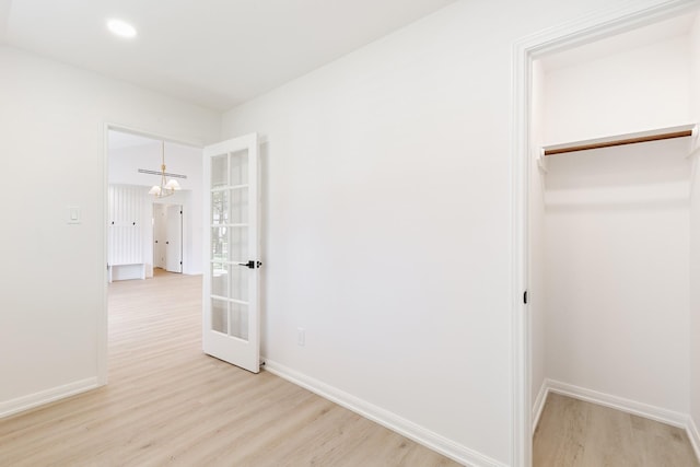 unfurnished bedroom with recessed lighting, light wood-type flooring, baseboards, and an inviting chandelier