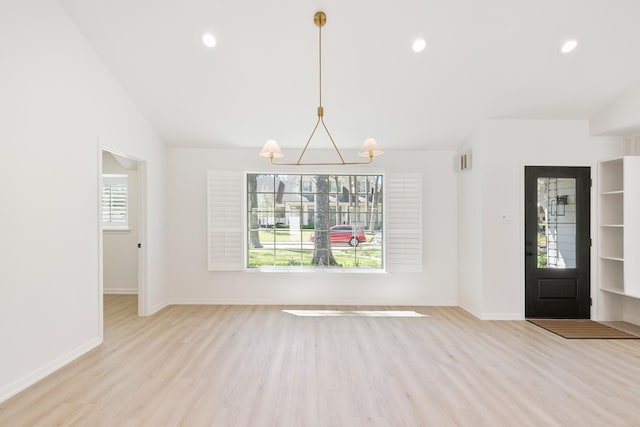 unfurnished dining area with vaulted ceiling, a notable chandelier, baseboards, and light wood-type flooring