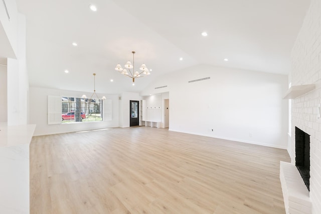 unfurnished living room with recessed lighting, an inviting chandelier, a fireplace, light wood finished floors, and vaulted ceiling