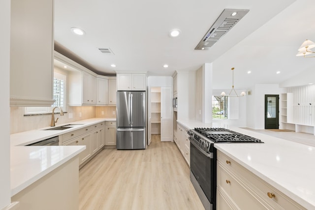 kitchen featuring a sink, visible vents, light wood-type flooring, and appliances with stainless steel finishes