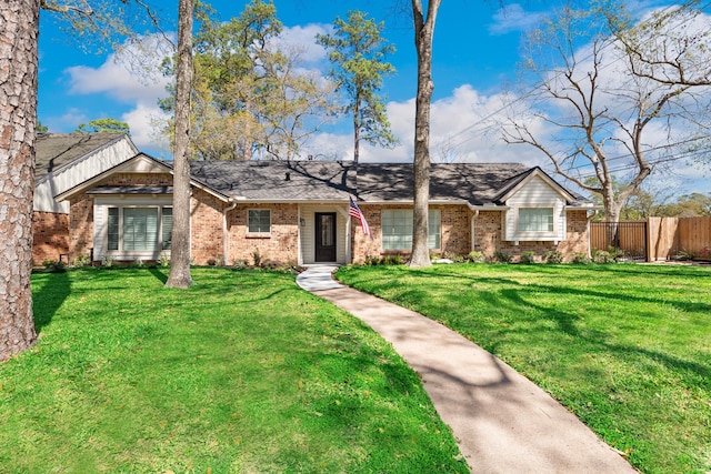 ranch-style house with a front lawn, fence, and brick siding