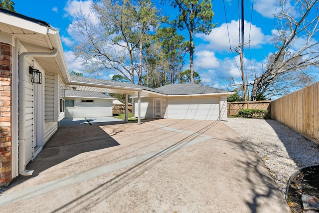 exterior space featuring an outbuilding, brick siding, a garage, and fence