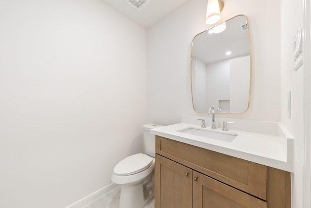 bathroom featuring visible vents, toilet, vanity, and baseboards