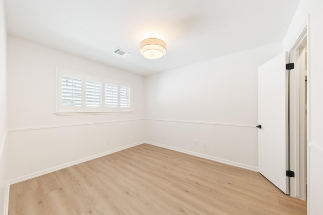 empty room with visible vents, baseboards, and light wood finished floors