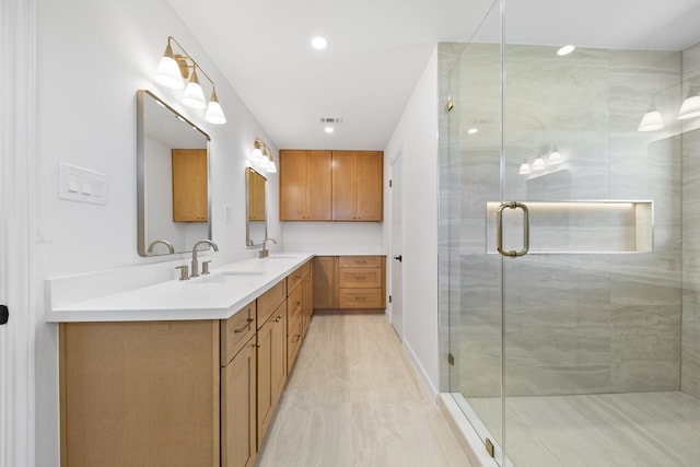 full bathroom featuring double vanity, recessed lighting, a shower stall, and a sink