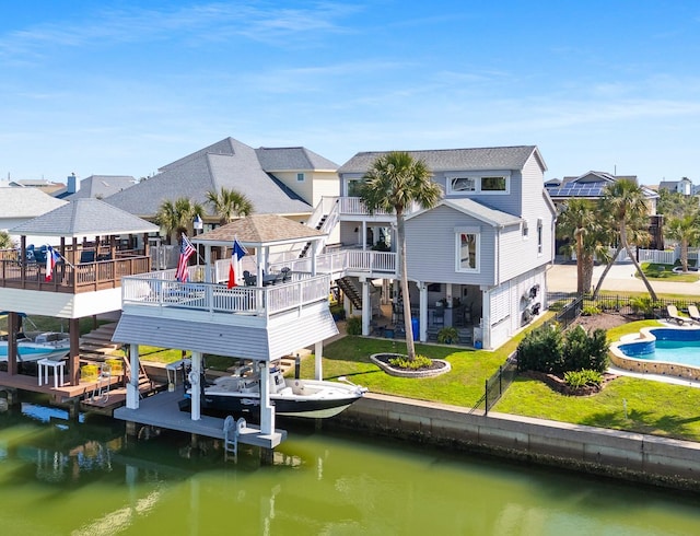 back of property featuring a fenced in pool, boat lift, a residential view, a water view, and a yard