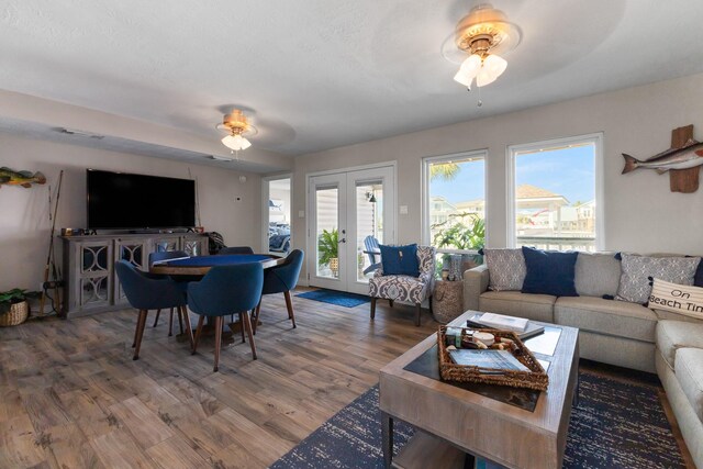 living room featuring ceiling fan, wood finished floors, and french doors