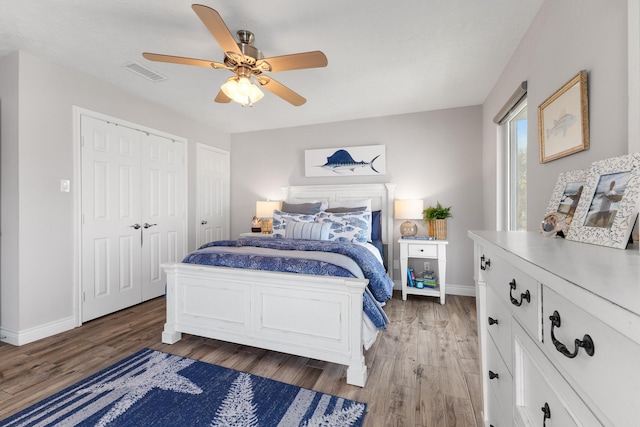 bedroom featuring light wood-style flooring, visible vents, and baseboards