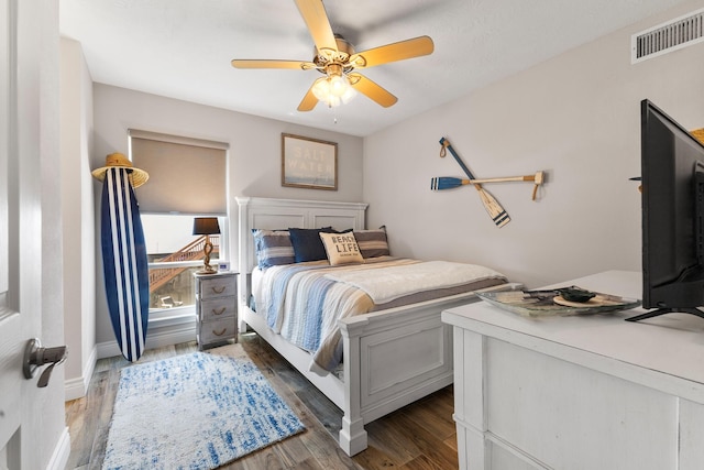 bedroom with visible vents, ceiling fan, baseboards, and wood finished floors