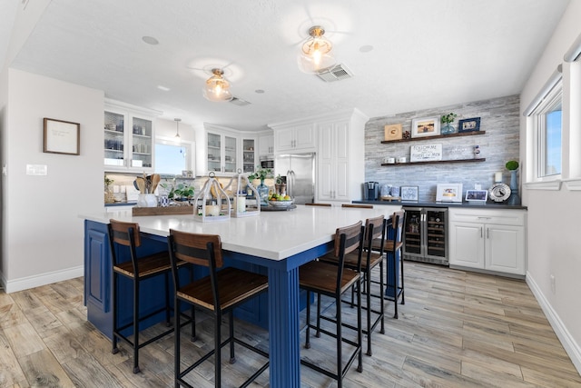 kitchen with white cabinetry, beverage cooler, visible vents, and stainless steel fridge with ice dispenser