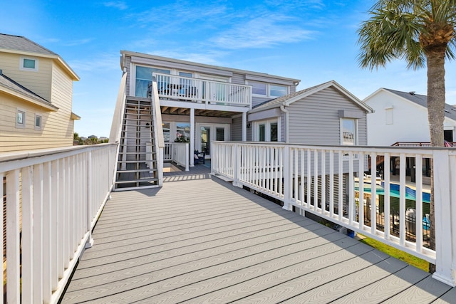 wooden terrace featuring stairs and an outdoor pool