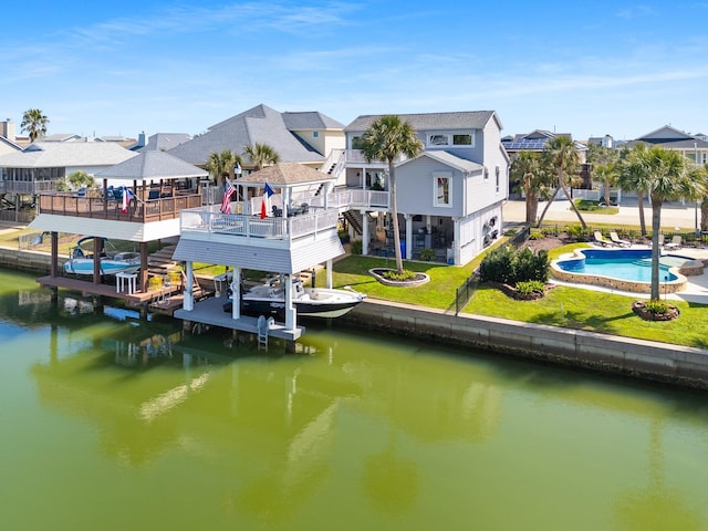 back of house featuring a lawn, a water view, a residential view, and a fenced in pool