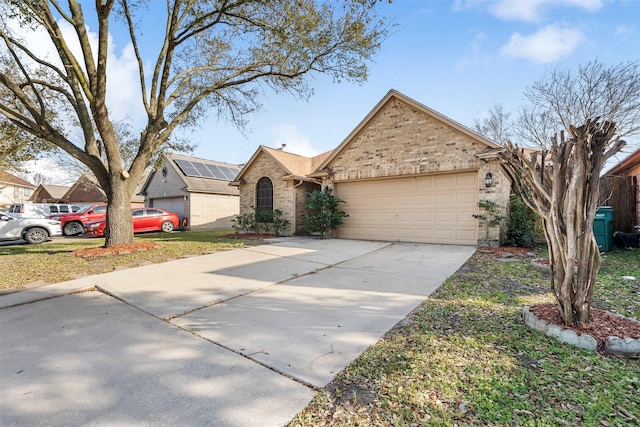 view of front facade featuring driveway, brick siding, and an attached garage