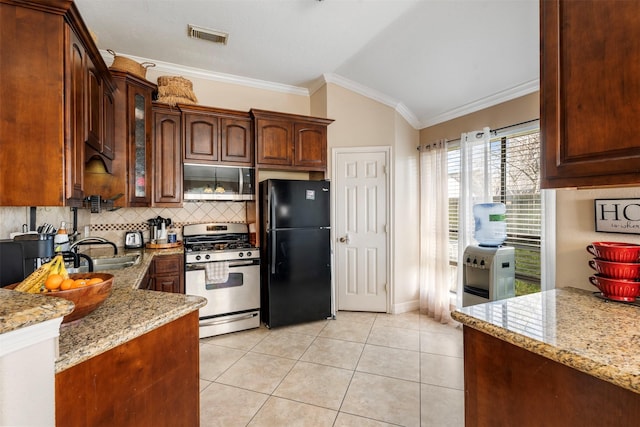 kitchen with stainless steel appliances, visible vents, decorative backsplash, light tile patterned flooring, and light stone countertops