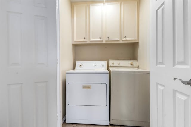 laundry area featuring separate washer and dryer and cabinet space