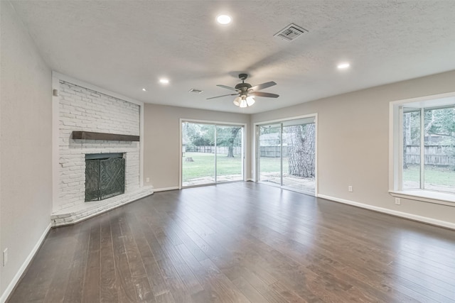 unfurnished living room featuring dark wood finished floors, visible vents, and a healthy amount of sunlight