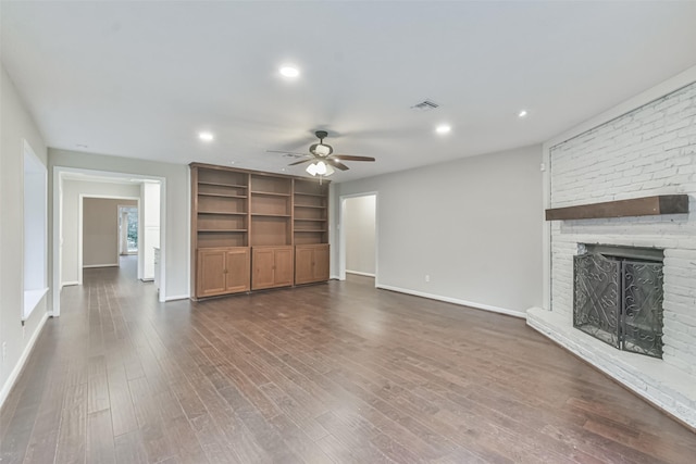 unfurnished living room featuring ceiling fan, recessed lighting, dark wood-style flooring, visible vents, and a brick fireplace