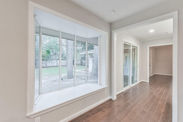 interior space with baseboards and wood finished floors