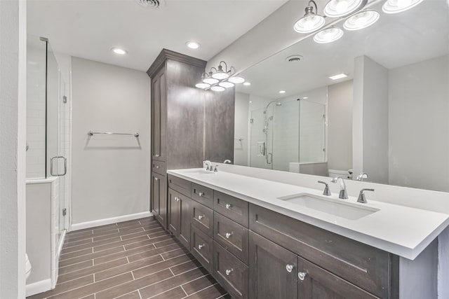 full bathroom with toilet, a sink, baseboards, a shower stall, and wood tiled floor