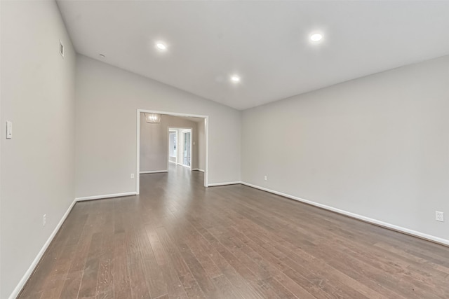 unfurnished room with lofted ceiling, dark wood-type flooring, recessed lighting, and baseboards