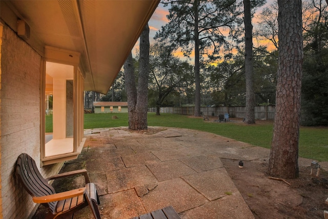 patio terrace at dusk with fence and a lawn