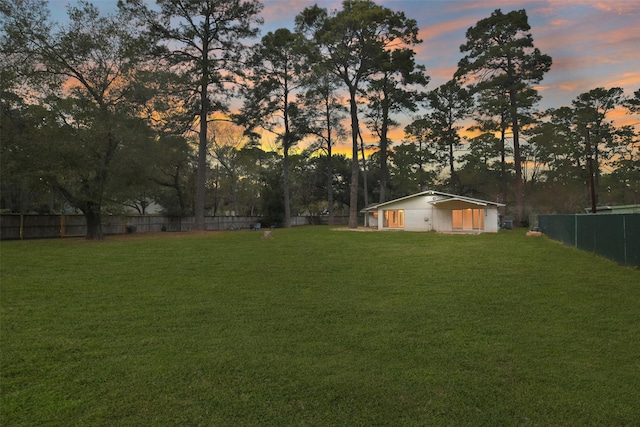 yard at dusk with a fenced backyard