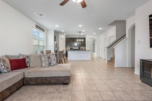 living area with light tile patterned floors, recessed lighting, a ceiling fan, visible vents, and stairway