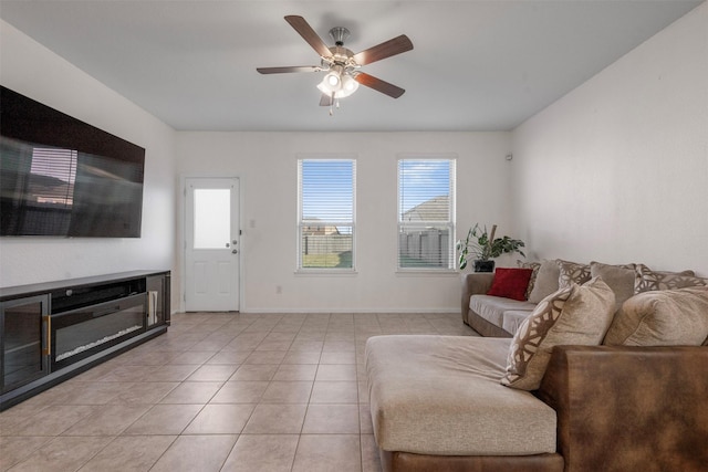 living room with light tile patterned floors, ceiling fan, and baseboards