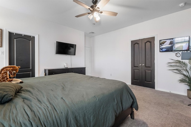 bedroom featuring baseboards, carpet flooring, visible vents, and a ceiling fan