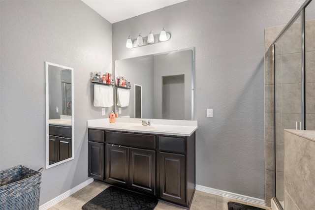 full bathroom featuring tile patterned floors, a shower stall, baseboards, and vanity