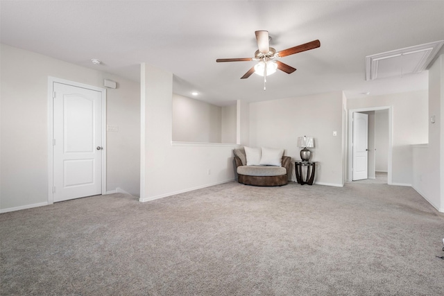 sitting room with carpet floors, attic access, baseboards, and ceiling fan