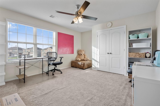 home office with a ceiling fan, carpet, visible vents, and baseboards