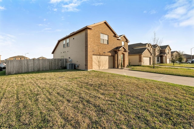 view of side of property with driveway, central AC unit, a lawn, fence, and brick siding