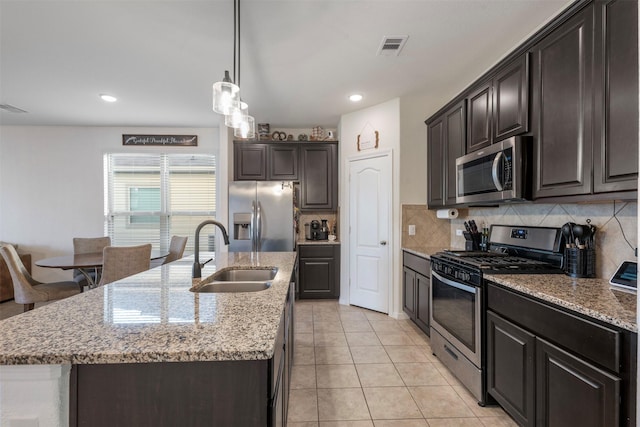 kitchen featuring stainless steel appliances, visible vents, a sink, and backsplash