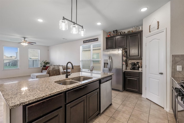 kitchen featuring an island with sink, a healthy amount of sunlight, stainless steel appliances, and a sink