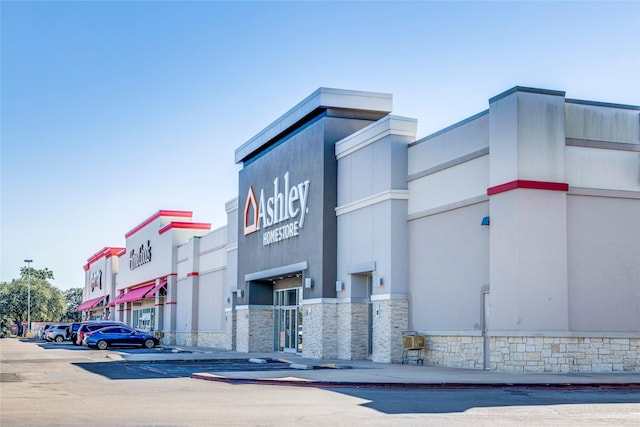 view of building exterior featuring uncovered parking