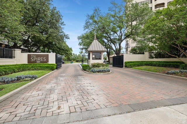 view of street with a gate, curbs, and a gated entry