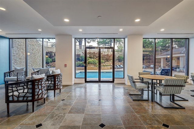 dining room featuring recessed lighting, floor to ceiling windows, and stone finish flooring