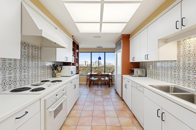 kitchen featuring white appliances, light tile patterned flooring, light countertops, and tasteful backsplash