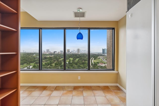 unfurnished dining area featuring baseboards, a city view, and tile patterned flooring