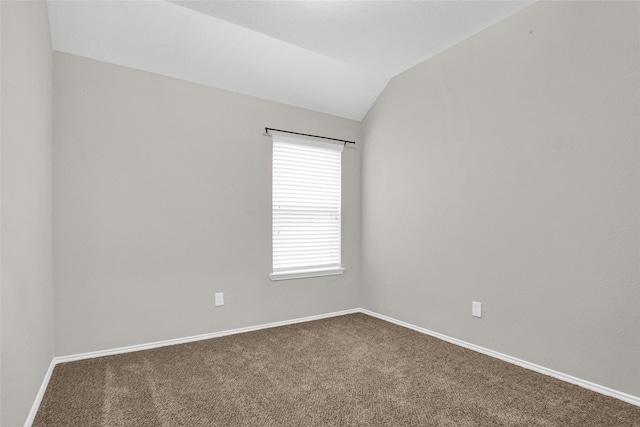 unfurnished room with baseboards, lofted ceiling, and carpet