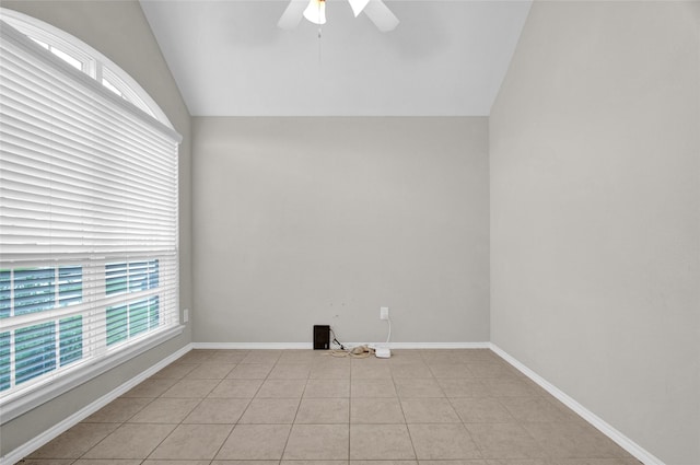 unfurnished room featuring baseboards, ceiling fan, light tile patterned flooring, and vaulted ceiling