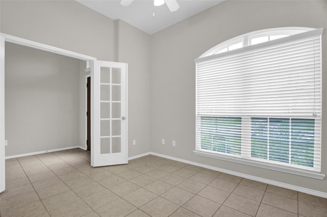 unfurnished room featuring baseboards, a healthy amount of sunlight, ceiling fan, and light tile patterned flooring