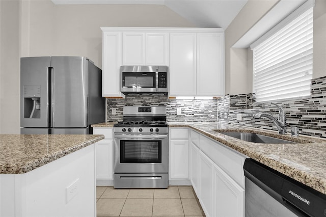 kitchen with white cabinets, light tile patterned flooring, appliances with stainless steel finishes, and a sink