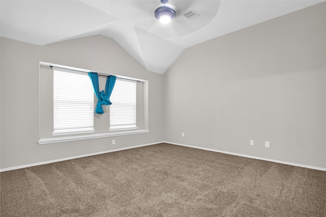 spare room with visible vents, a ceiling fan, carpet, baseboards, and vaulted ceiling