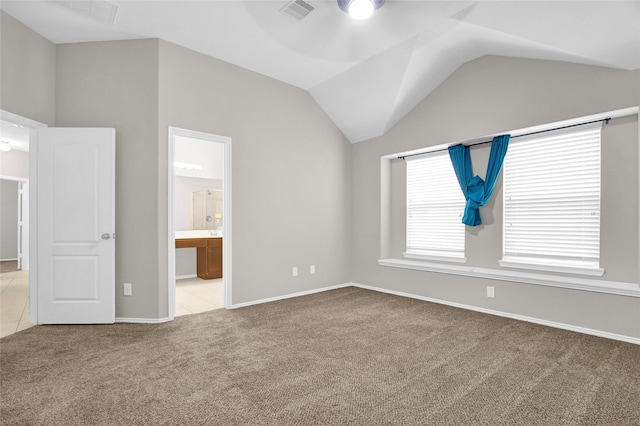 unfurnished bedroom with visible vents, carpet, ensuite bath, and vaulted ceiling