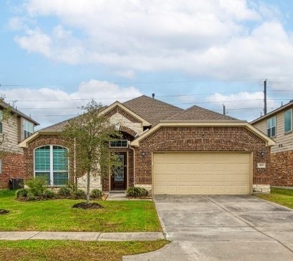 single story home featuring brick siding, a front lawn, concrete driveway, roof with shingles, and an attached garage