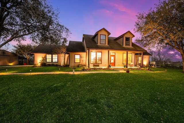 new england style home with a porch and a front lawn